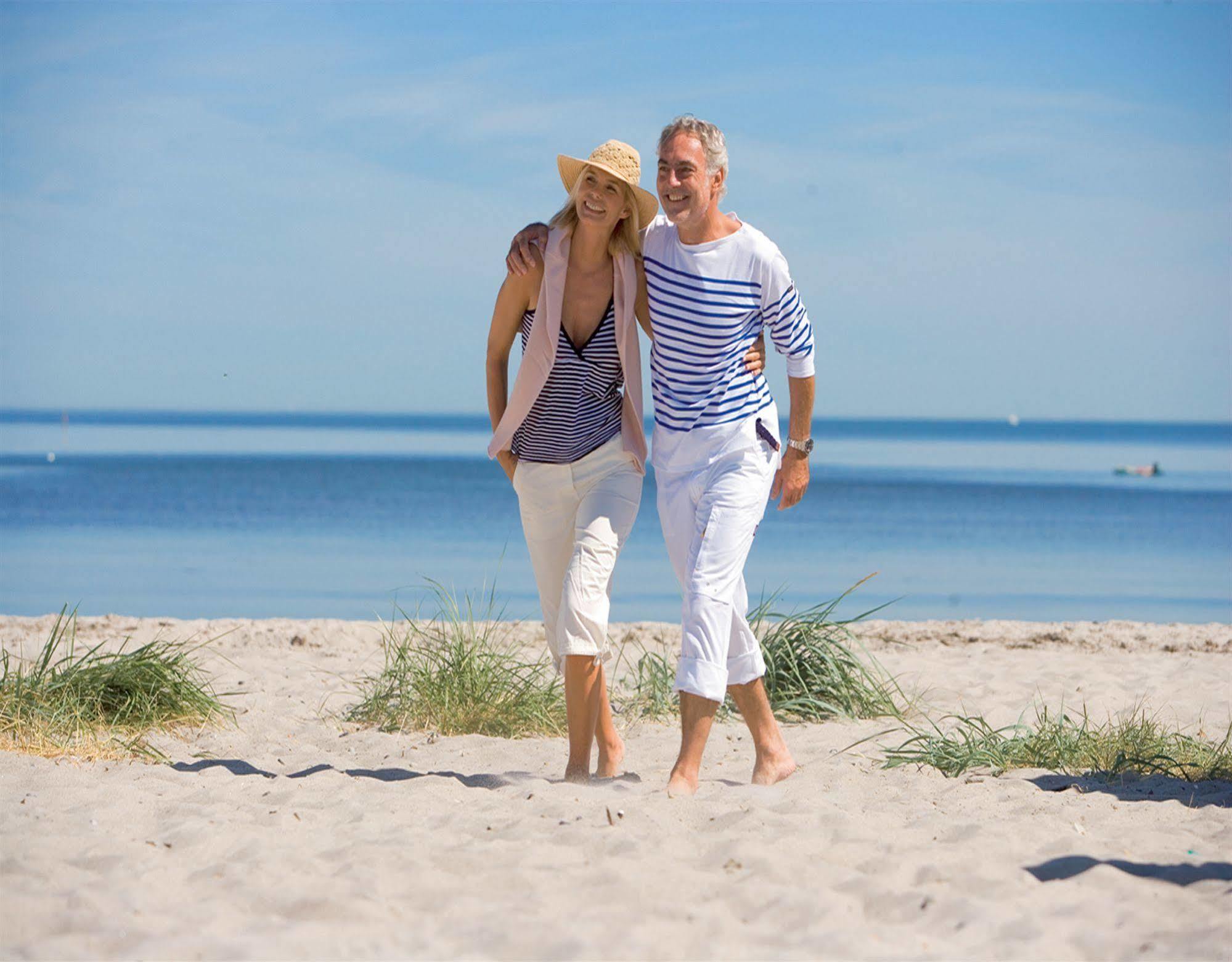Yachthafenresidenz Hohe Duene Hotel Rostock Kültér fotó A couple walking on the beach